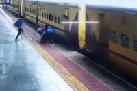 Cctv footage woman falls under moving train rescued