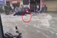 Man being washed away in floodwater at yousufguda in hyderabad